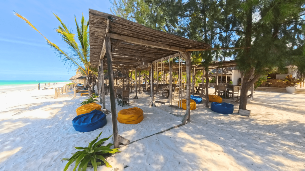 Image of Kite Bar on the beach:
"Kite Bar on Paje Beach, Zanzibar, offering a perfect spot to relax and enjoy refreshments after a kitesurfing session."
Image of kitesurfers enjoying drinks at the Kite Bar:
"Kitesurfers relaxing with drinks at the Kite Bar, sharing stories and enjoying the stunning ocean views on Paje Beach."
Image of refreshing drinks and snacks at the Kite Bar:
"Refreshing drinks and delicious snacks served at the Kite Bar, the ideal place to refuel after kitesurfing in Zanzibar."
Image of the shaded seating area at the Kite Bar:
"Shaded seating area at the Kite Bar, providing a cool and comfortable place for kitesurfers to unwind on Paje Beach."